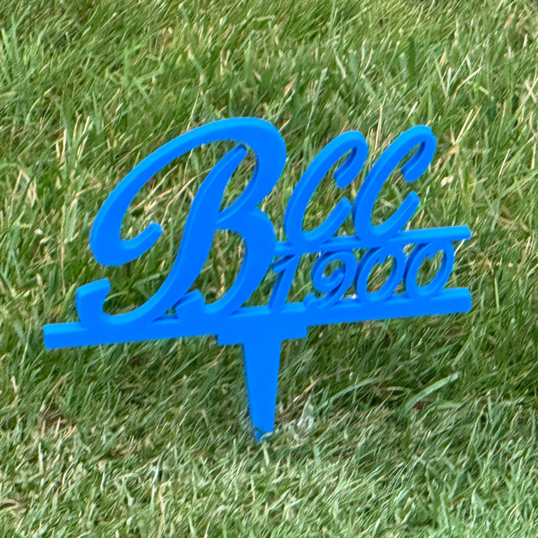 Elegant blue BCC 1900 script tee sign on grass - showcasing beautiful cursive lettering for golf tournaments and commemorative events